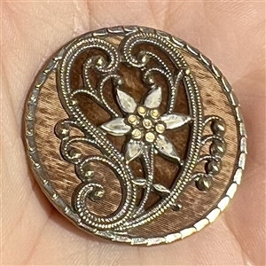 Delicate stamped brass design with velvet behind heart and other fabric background.