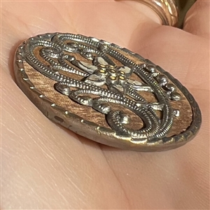 Delicate stamped brass design with velvet behind heart and other fabric background.