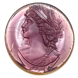 Amethyst glass in metal button of a woman's head in profile.