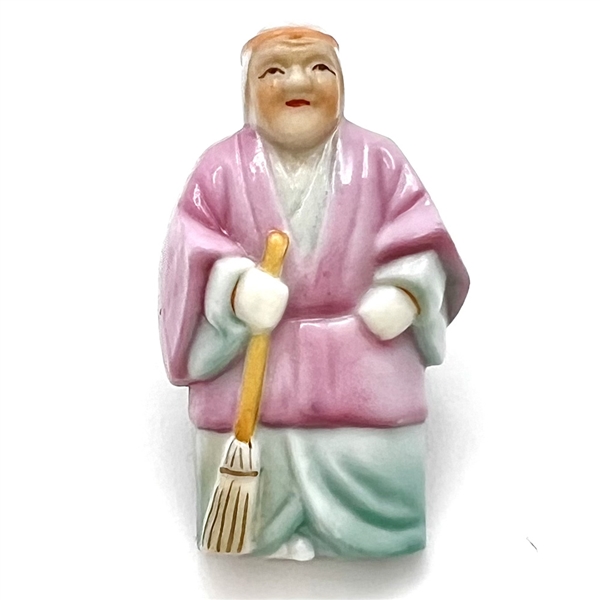 Japanese Arita porcelain button of a realistic figure with a broom.