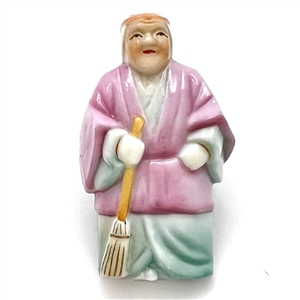 Japanese Arita porcelain button of a realistic figure with a broom.