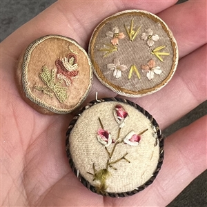 Three 19th c. Fabric buttons of flowers.