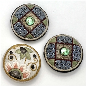 Three Edwardian fabric buttons.