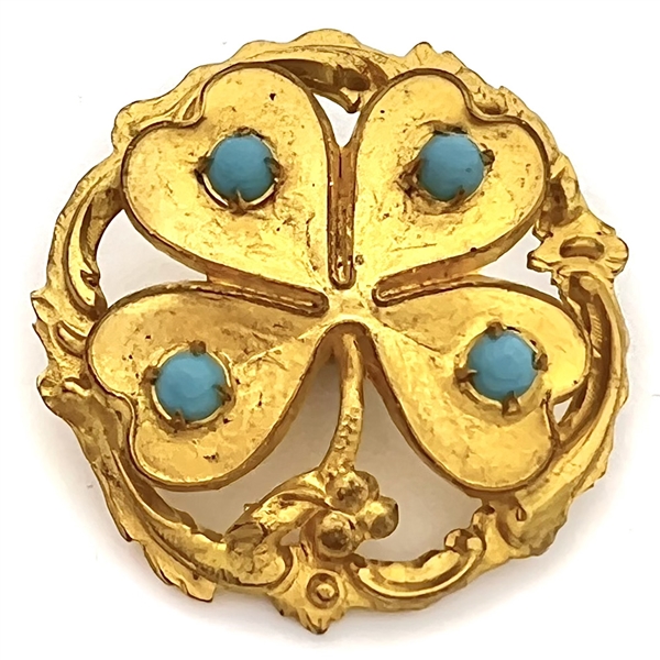 Brass button of a four leaf clover with turquoise glass.