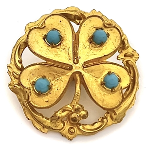 Brass button of a four leaf clover with turquoise glass.