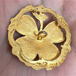 Brass button of a four leaf clover with turquoise glass.