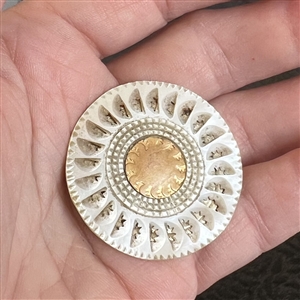 An 18th c. pearl button with carved slits and gold center.