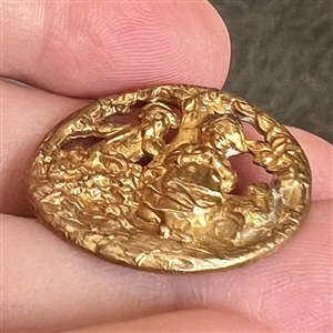 A 19th c. brass button of two children.