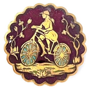 Enamel button of a girl riding a bicycle. 
