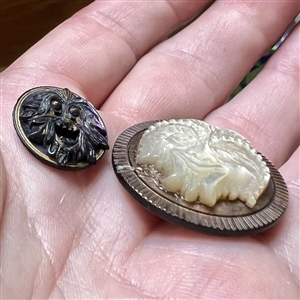 Two Greenman buttons of carved united pearl. 