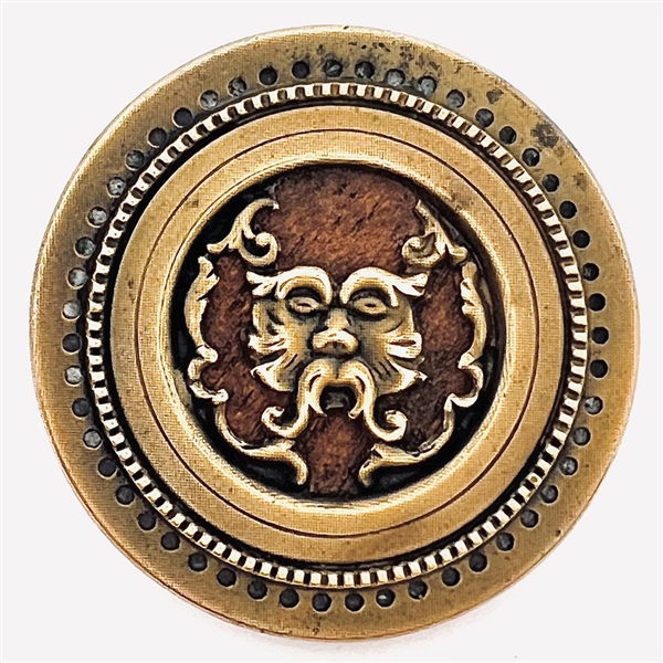 Brass Greenman button with a wood background.