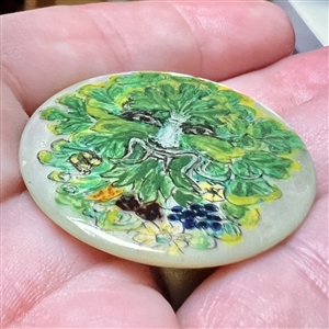 Painted pearl studio button of a Greenman.