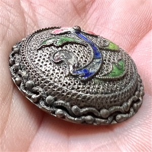 Silvered copper Asian button of an enameled flower.