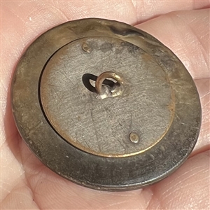 A 19th c. grey pearl button with metal design.