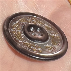 A 19th c. 4-hole pearl button of incised and pierced plant life.