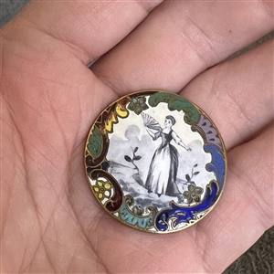 A 19th c. enamel button of woman with a fan.