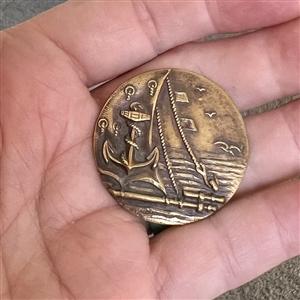 A 19th c. Brass button of fouled anchor and sea scene from ship. 