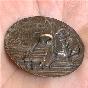 A 19th c. Brass button of fouled anchor and sea scene from ship. 