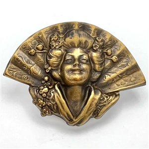 Stamped brass in high relief button of a realistic fan behind a Asian woman.